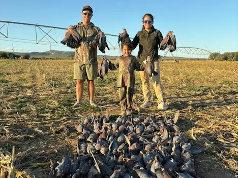 Two hunters proudly posing with their duck and geese they shot after another successfull hunting expedition